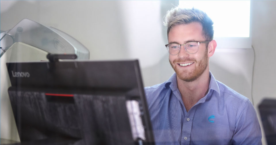 Smiling Man Looking at Computer Screen | MRI Specialist | FMIG